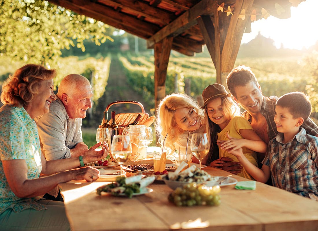 Insurance Solutions - Multigenerational Family Having a Family Lunch Outdoors on a Patio